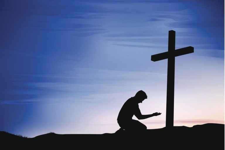 Man kneeling before a cross in front of a blue sunset